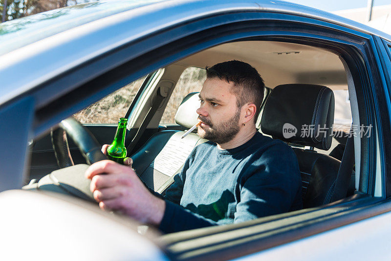 一边开车一边喝啤酒的男人