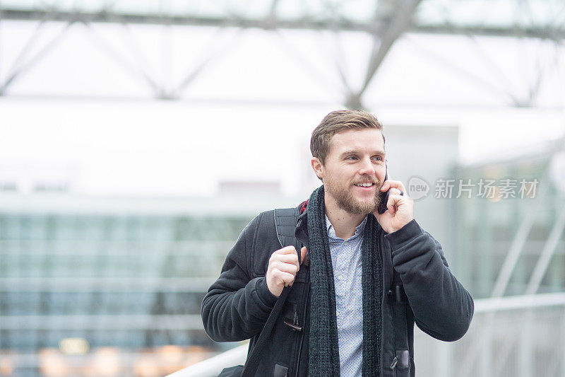 穿着时髦的男性商务旅行者在电话中离开机场