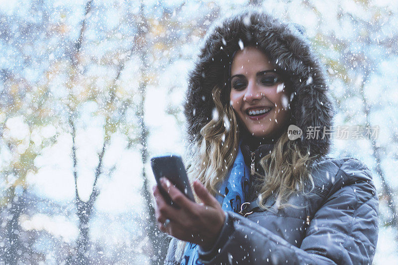 女人在下雪天使用电话