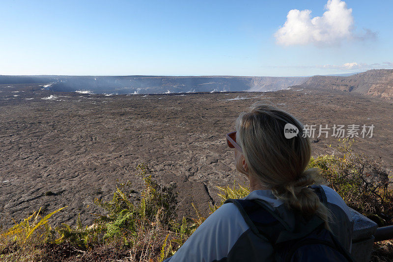 一名女性徒步旅行者眺望远处的火山熔岩