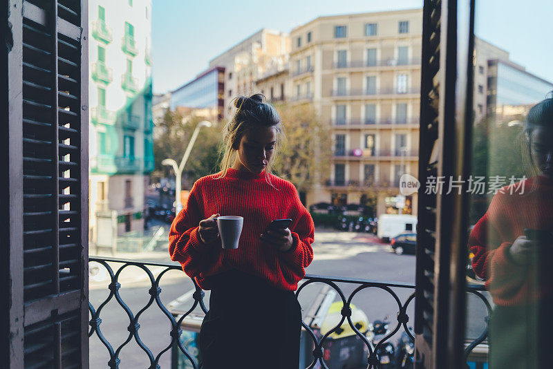 可爱的女孩在巴塞罗那的阳台上发短信