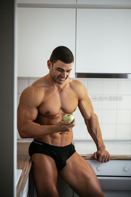 健康的生活方式。肌肉男吃苹果