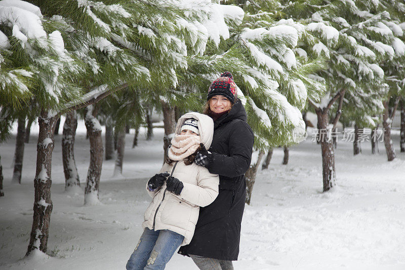 妈妈和女儿在雪中玩耍