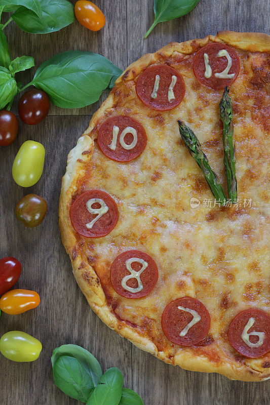 这是一个自制的披萨时钟，上面有意大利辣香肠片、马苏里拉奶酪和芦笋作为时钟指针，显示时间是11点11分。这是意大利披萨餐厅为孩子们的生日聚会食物准备的儿童披萨时钟
