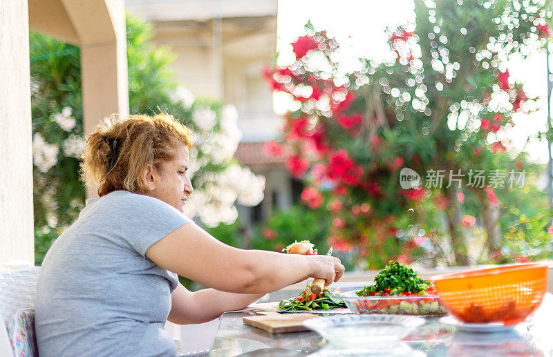 在阳台上准备沙拉的女人