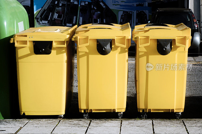 三个黄色垃圾桶用于回收。