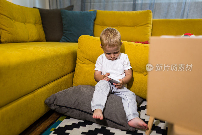 一个小男孩正在用智能手机看动画片