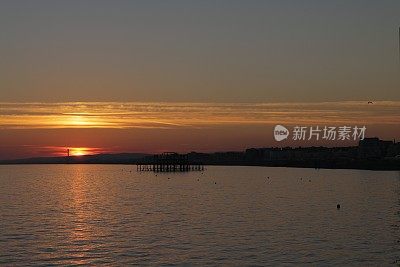 布赖顿西码头与戏剧性的日落天空在海上和城市沿海天际线布赖顿，东苏塞克斯，英国，从布赖顿码头，布赖顿海滩的黄昏照片