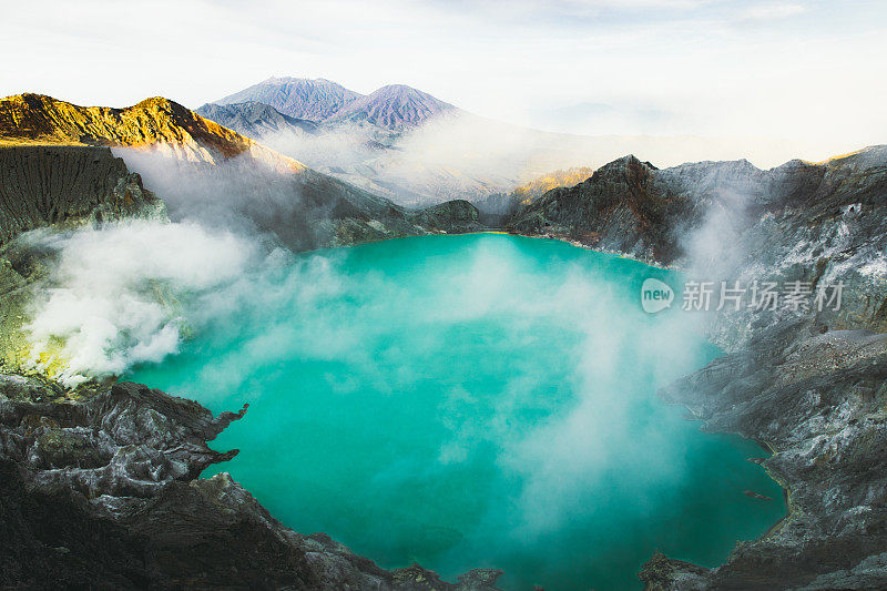 印度尼西亚东爪哇的伊真火山火山口的绿松石色湖泊，山脉和硫磺蒸汽的戏剧性景色