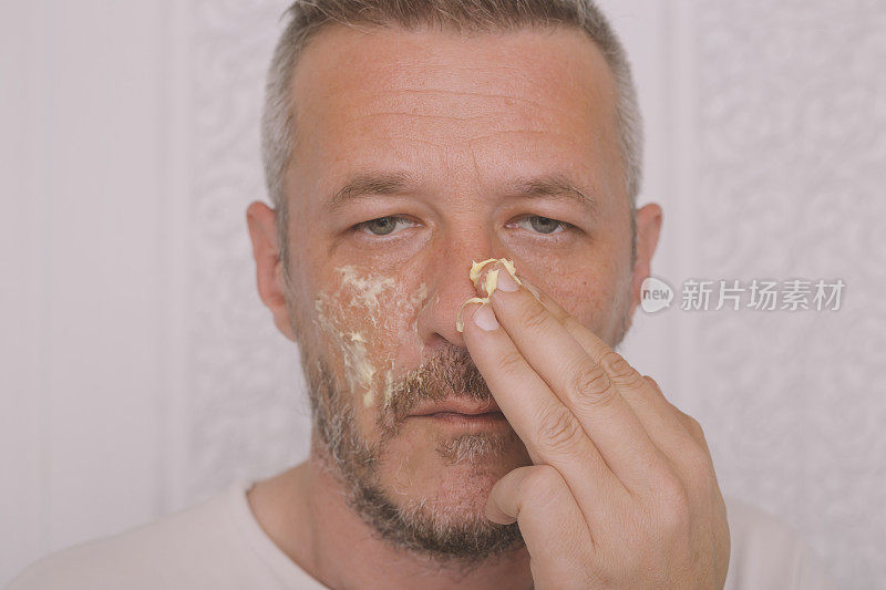 成年男子在脸上擦护肤霜