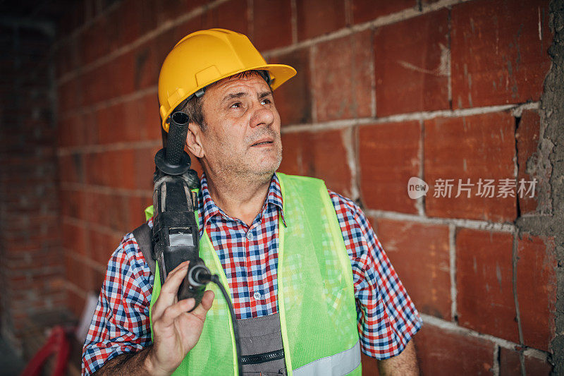 建筑工人拿着钻头钻混凝土