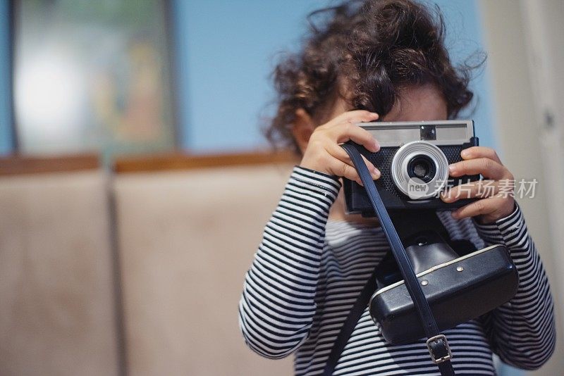 一个小女孩在学用她的第一部相机