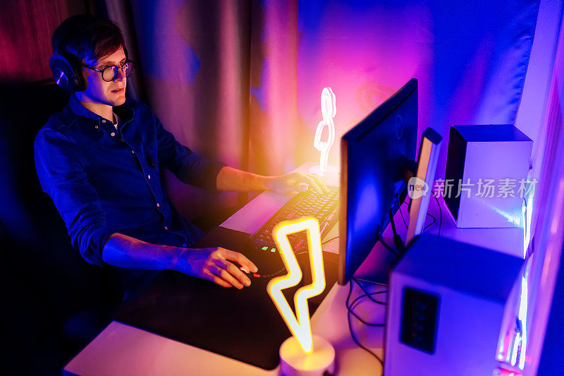 玩家坐在有霓虹灯的房间里，以个人电脑的第一人称玩在线视频游戏