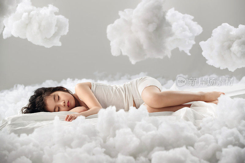 可爱的小女孩躺在云朵上