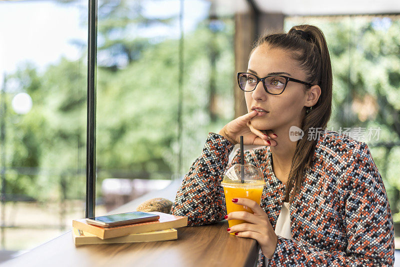 一个在快餐店里拿着书的年轻女子