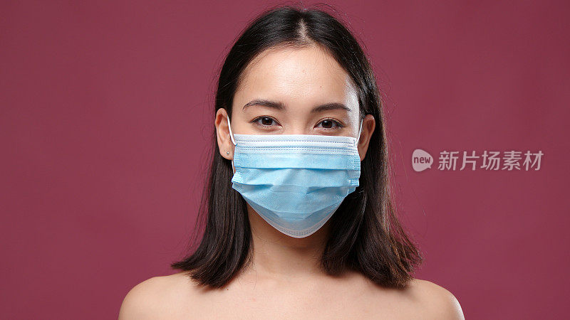 年轻的亚洲女人戴着医用口罩对抗玛萨拉
