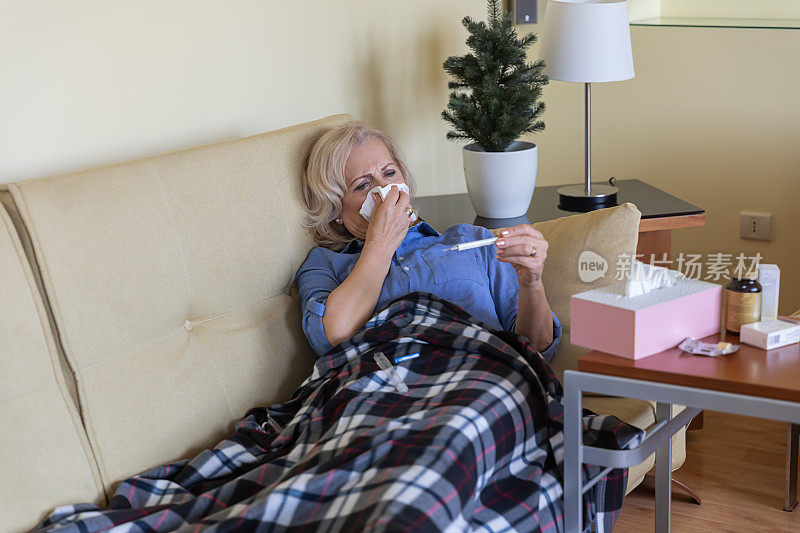 一位患季节性流感的妇女躺在床上检查体温。