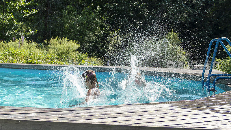 高加索儿童在室外游泳池愉快地游泳。两个女孩，一个6岁，一个8岁，在一个夏日的室外游泳池里游泳。