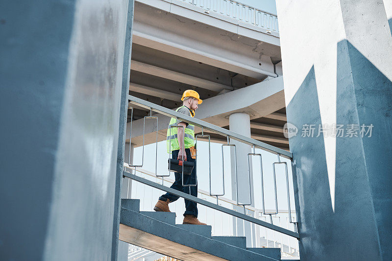 建筑商站在施工现场未完工的公寓大楼的广角视野，复制空间