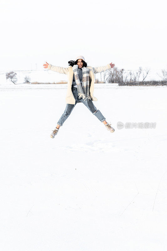 年轻女子在冬天的雪地里玩得很开心