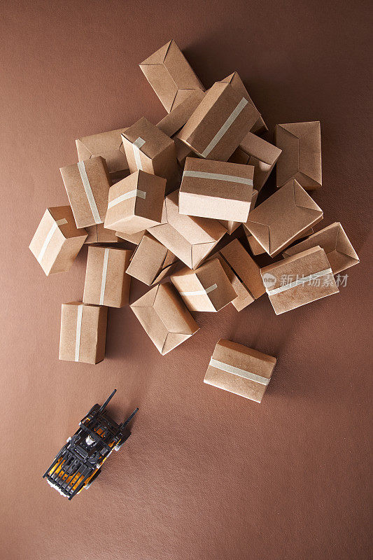 一堆棕色的纸板箱与玩具叉车准备交付。