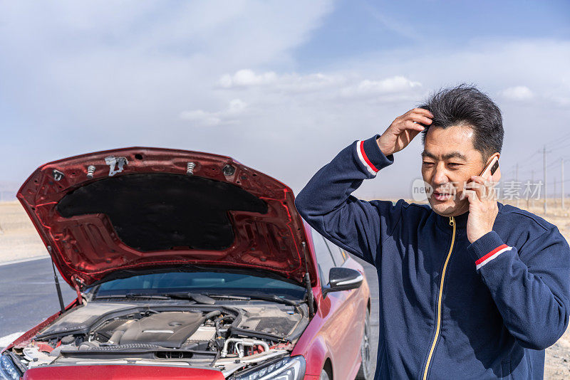 汽车在荒野地区的路上抛锚了，那个中年亚洲人正在修车