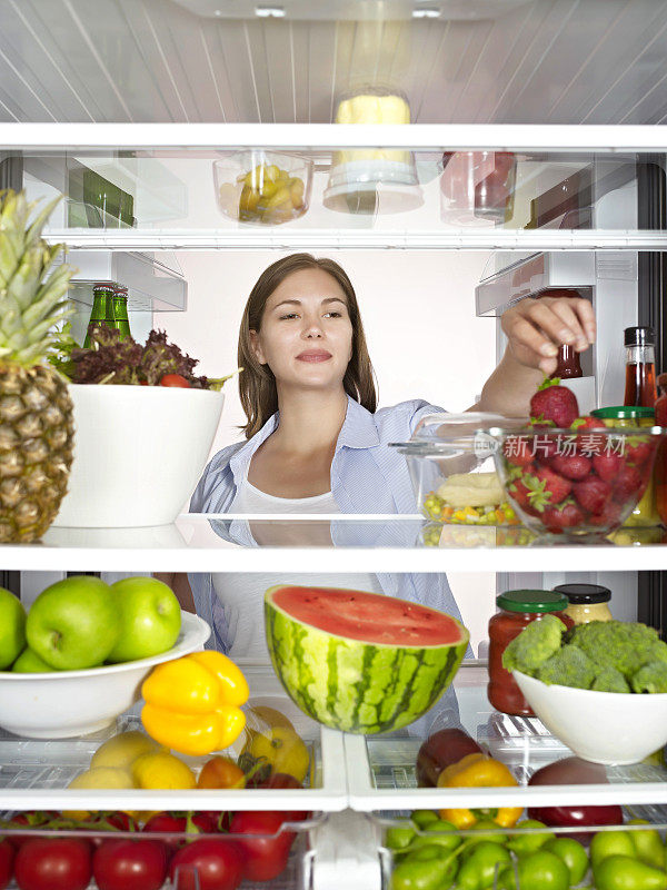 一位年轻女士在冰箱里翻看健康食品