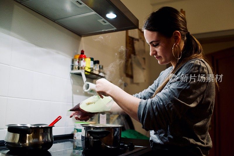 年轻女子在准备新鲜的意大利面