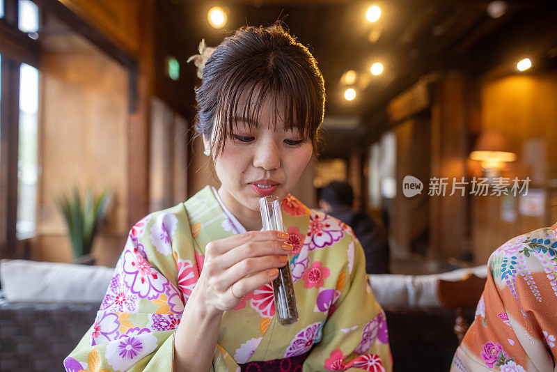 穿着和服的日本女人在咖啡馆闻着茶叶的香味