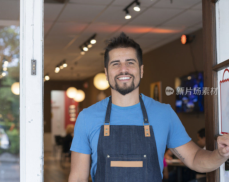 肖像快乐的男性企业家打开商店的门在咖啡店