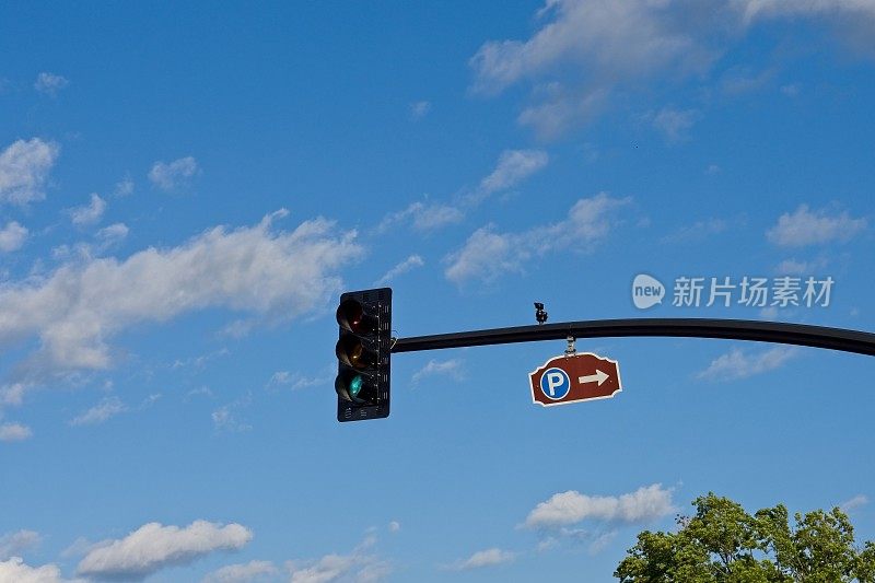 停车标志和红绿灯的背景是蓝色的天空与蓬松的积云