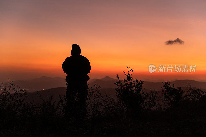 黄昏时，红艳艳的晚霞漫天，一个人的背影就在山上