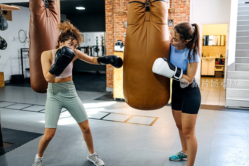 年轻的运动女性在健身房打拳击