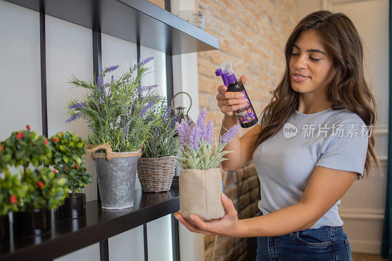 年轻女子在她的新公寓里照料植物