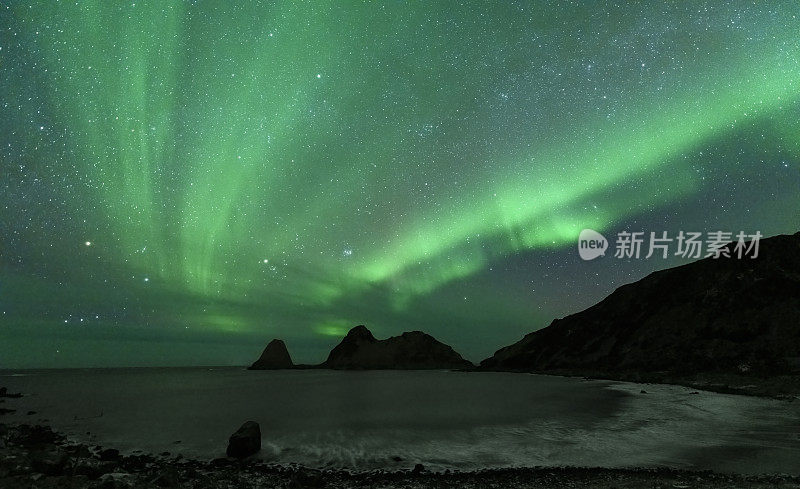 北极光或极光在繁星密布的夜空中在挪威北部的Nykvag海滩