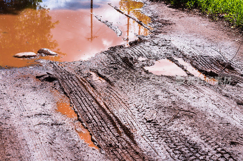 泥泞的水坑，轮胎印穿过泥泞