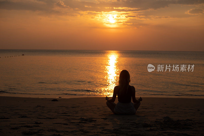 瑜伽和冥想平静和平的海滩日落适合年轻女子