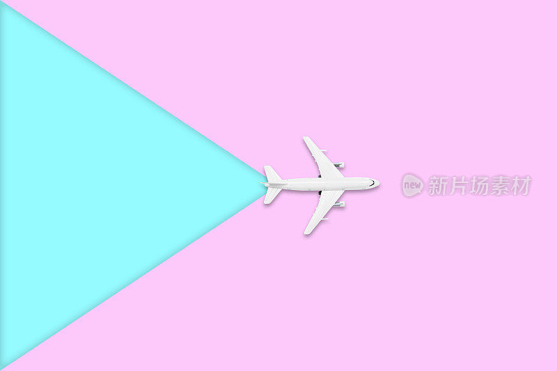 夏季旅游概念的平面设计。一架飞机的俯视图在空白的粉红色和蓝色柔和的彩色屏幕与复制空间。暑假旅行