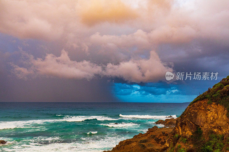 日落照亮的海洋上戏剧性的风暴单体系统的海岸海景