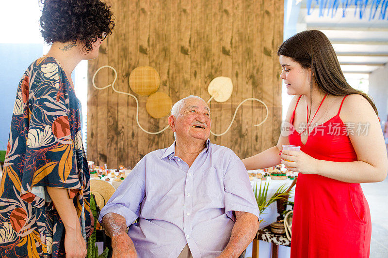 爷爷在他的生日聚会上和他的孙女们一起大笑