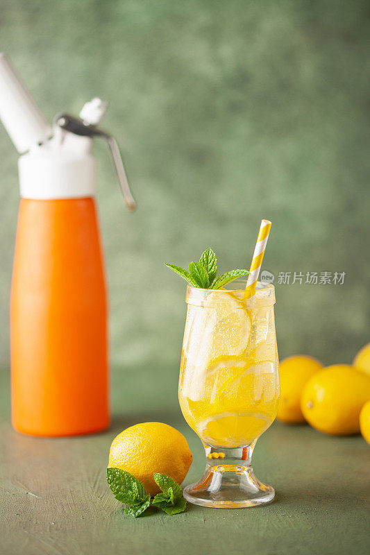 自制的玻璃杯柠檬水。碳酸饮料碳酸氧化物柠檬水液体由二氧化碳虹吸分配器瓶。