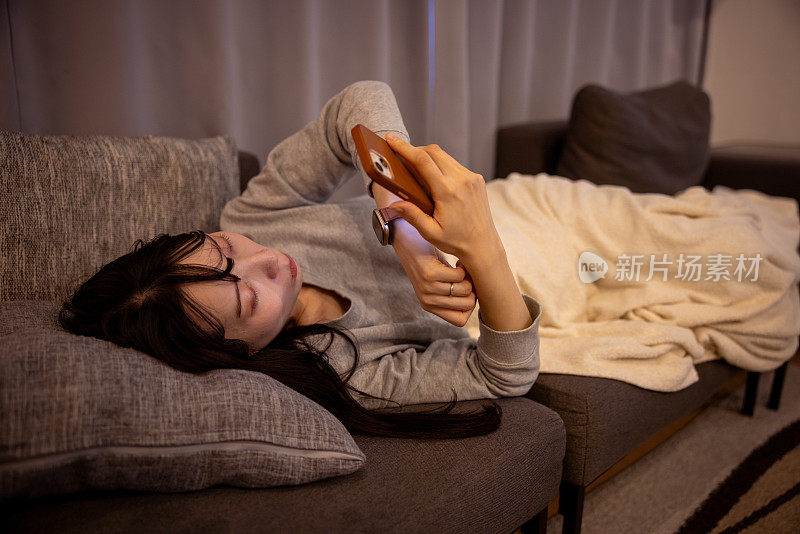 女人在睡觉前使用智能手机——全身着地