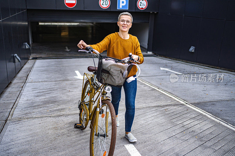 一个留着短发的白人女人在她的自行车旁走过城市