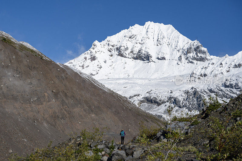 徒步旅行者在雪山下的山脊上休息