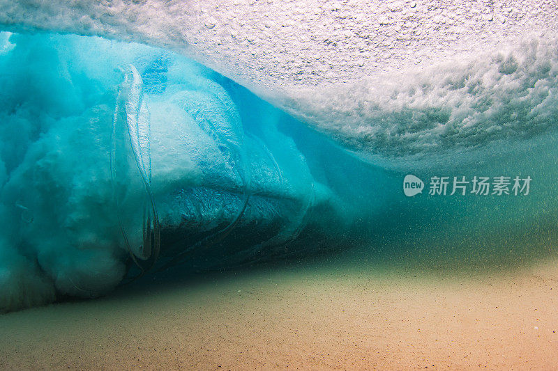 在清澈的海水中，海浪拍打着沙滩，水下的景色一览无余