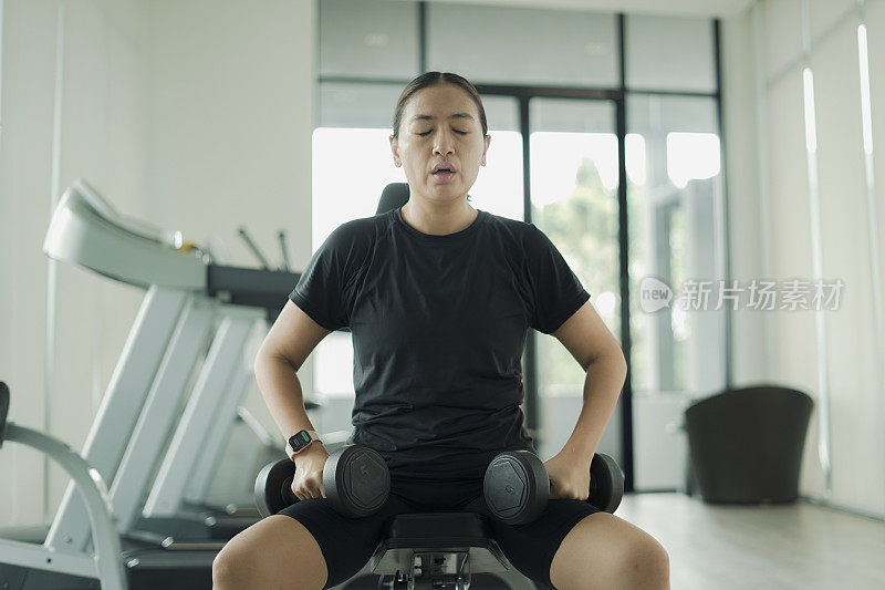 女子在健身房举哑铃