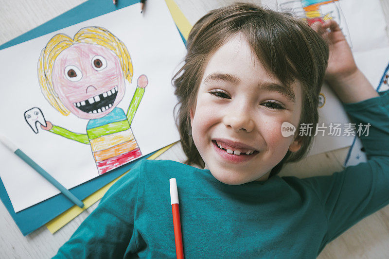 缺牙的可爱男孩在画自画像