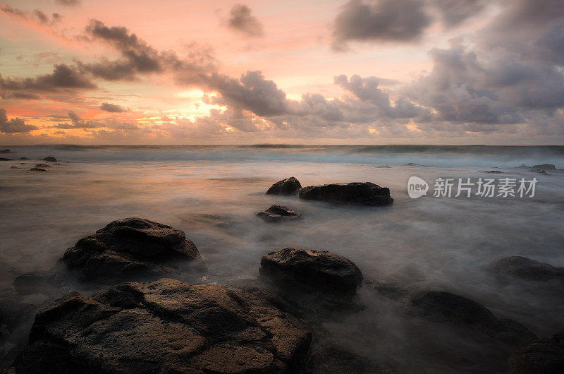 考艾岛海岸的日出，缓慢的快门模糊了涌来的海浪