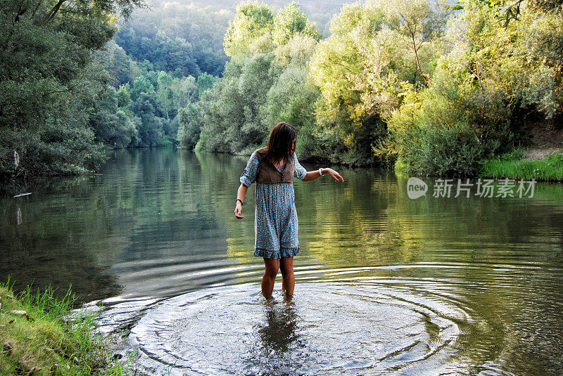 年轻女子在湖里玩水