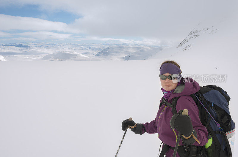 女backcountry滑雪者在高海拔冰川背包